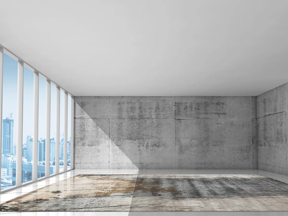 Foto of a building in a metropolitan city with concrete walls and a Rug with blue, brown and sand shades positioned in the middle covering the floor.